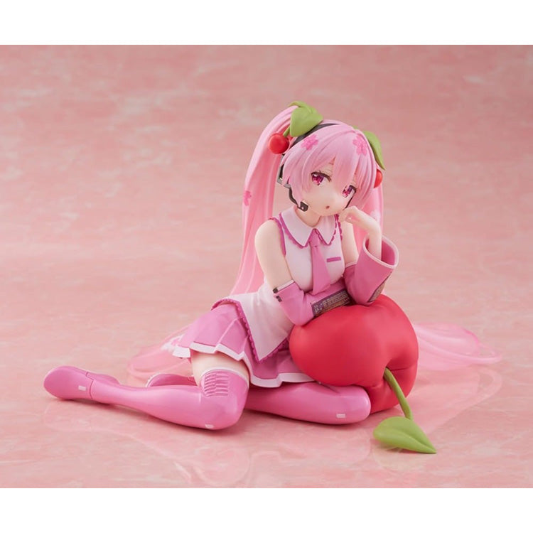 Hatsune Miku Sakura Miku Cherry Cushion Ver. figure by Taito sitting against a cherry cushion with pink Sakura-inspired colors.