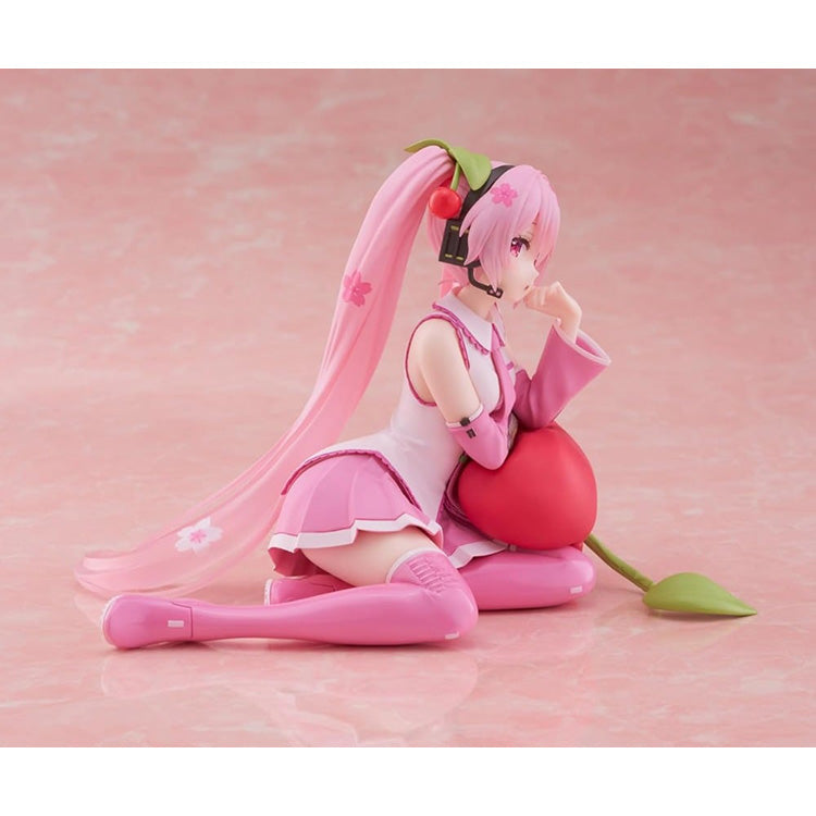 Hatsune Miku Sakura Miku Cherry Cushion Ver. figure by Taito sitting against a cherry cushion with pink Sakura-inspired colors.