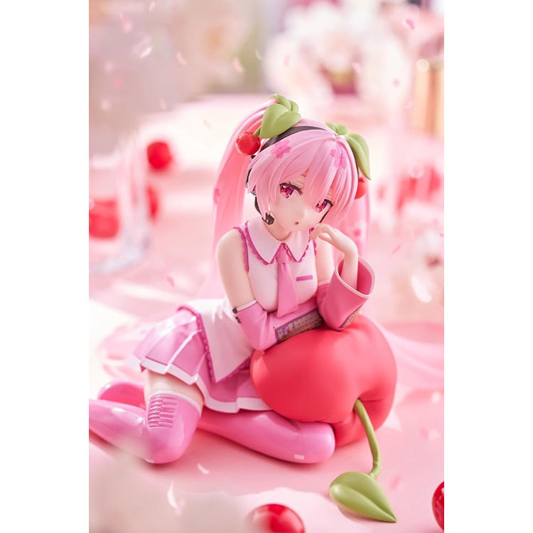 Hatsune Miku Sakura Miku Cherry Cushion Ver. figure by Taito sitting against a cherry cushion with pink Sakura-inspired colors.