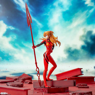 Shin Evangelion Theatrical Version Luminasta figure of Asuka Langley Shikinami wearing a glossy red plugsuit, standing in a dynamic pose while holding the large Spear of Cassius. The figure is displayed on a red base with a marble-like background.