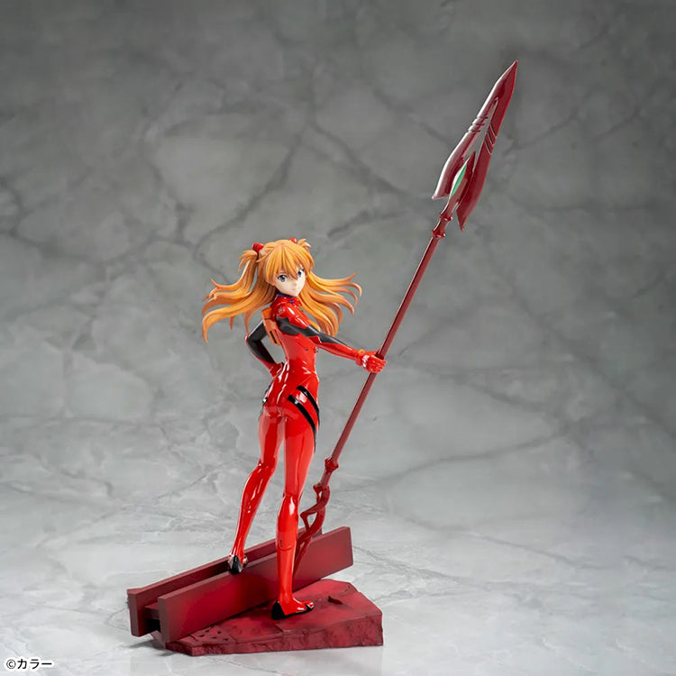 Shin Evangelion Theatrical Version Luminasta figure of Asuka Langley Shikinami wearing a glossy red plugsuit, standing in a dynamic pose while holding the large Spear of Cassius. The figure is displayed on a red base with a marble-like background.