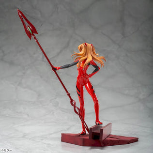 Shin Evangelion Theatrical Version Luminasta figure of Asuka Langley Shikinami wearing a glossy red plugsuit, standing in a dynamic pose while holding the large Spear of Cassius. The figure is displayed on a red base with a marble-like background.