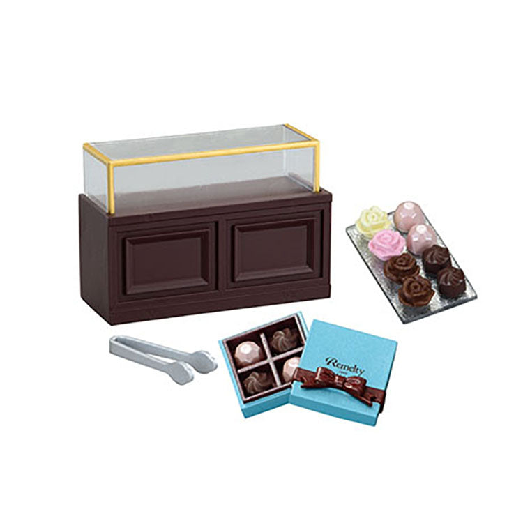 Miniature chocolate shop set from the Re-Ment Petit Chocolaterie series, featuring tiny chocolates, desserts, and a display showcase.